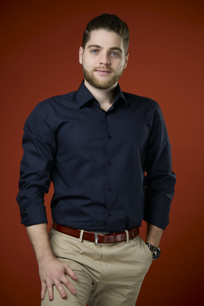 Bărbat în cămașă bleumarin, portret profesional pe fundal portocaliu