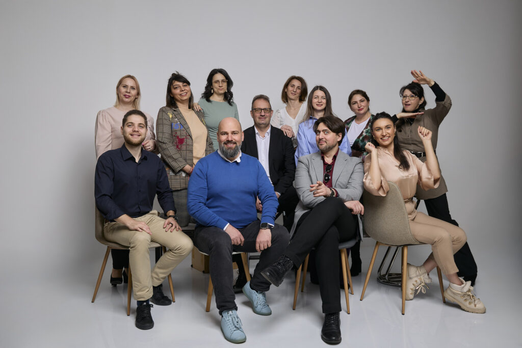 Fotografie de echipă în studio, cu ținute în aceeași gamă de culori